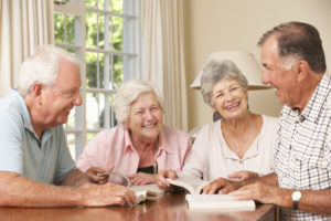 Group Of Senior Couples Attending Book Reading Group Smiling And Laughing.