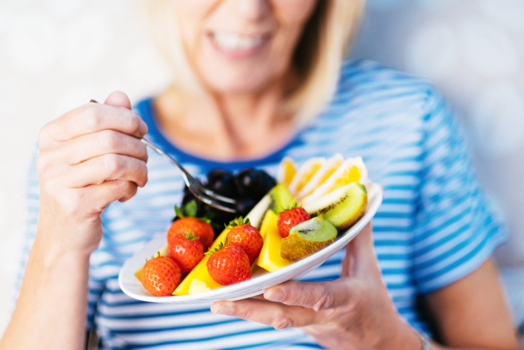 Attractive senior woman with fruit lunch