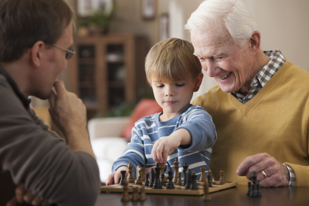 Caucasian grandfather and grandson playing chess