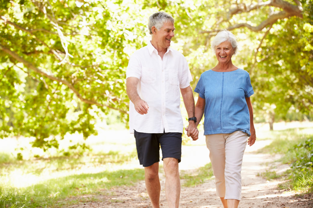 Senior couple walking on a path together in the countryside