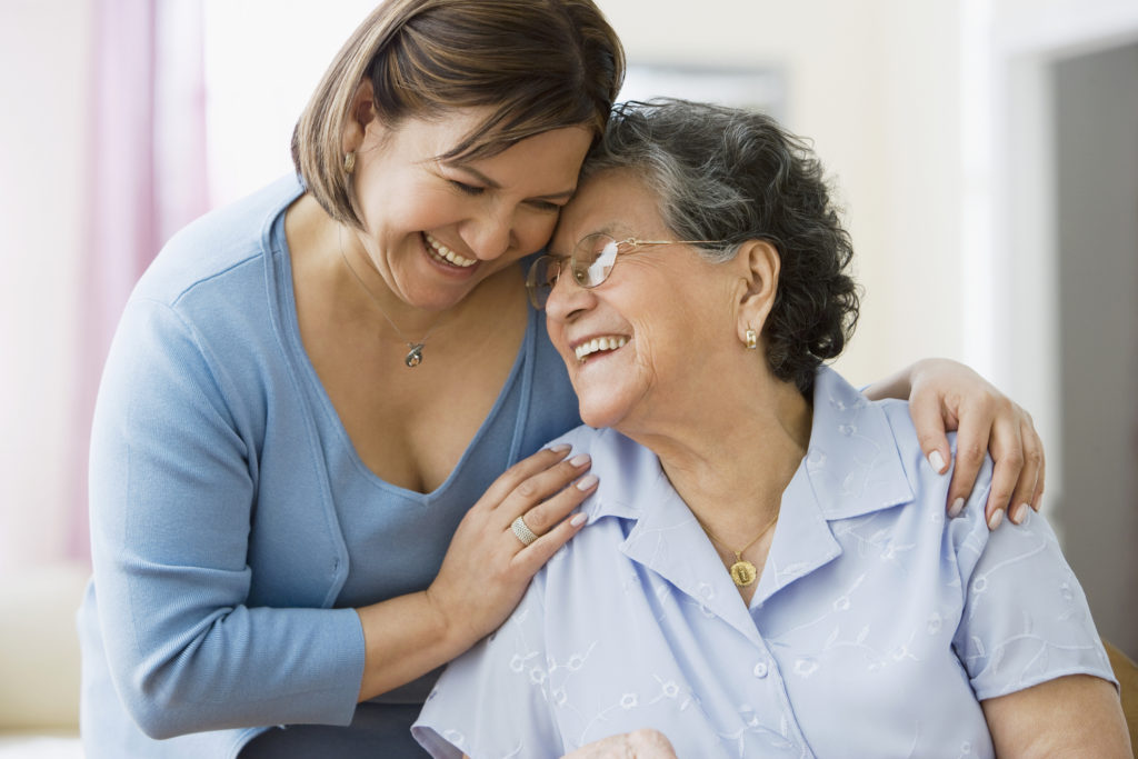 Hispanic mother and adult daughter hugging