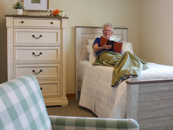 Senior woman sitting in bed reading book