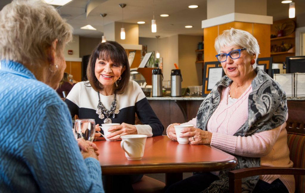 three older women drinking coffee together