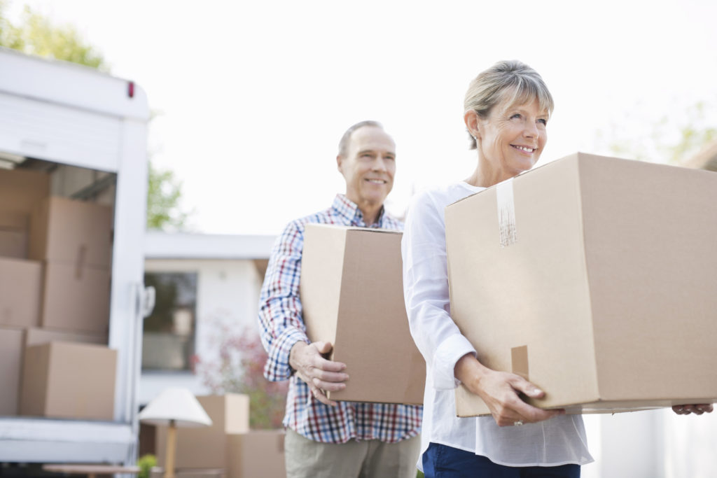 Couple unloading boxes from moving van