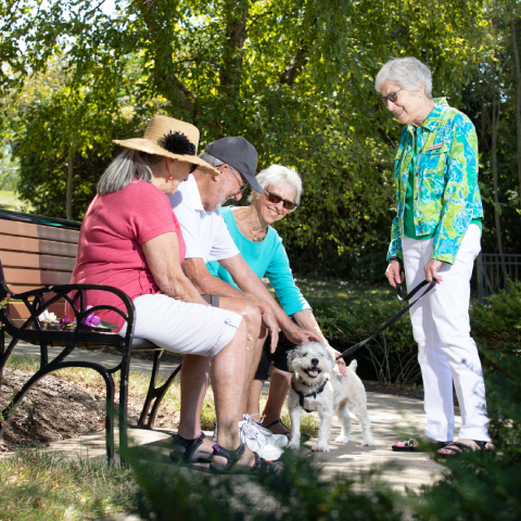 Senior living residents talking outside and sitting on a bench