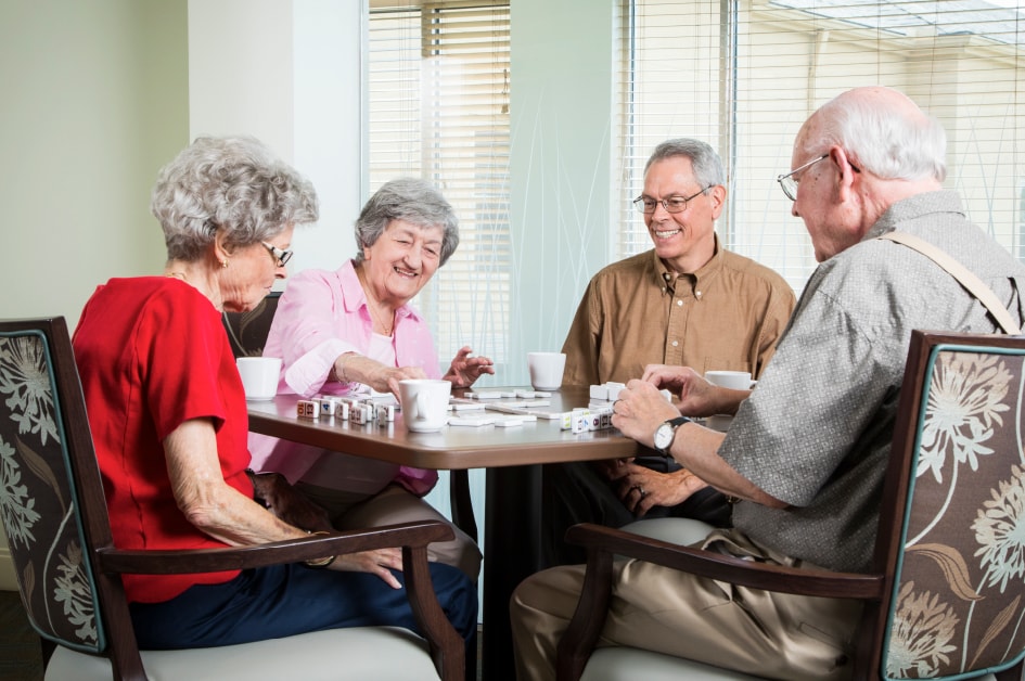 group of mature adults playing dominoes