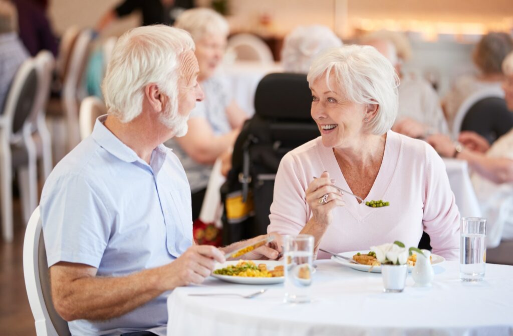 A senior living couple eating together