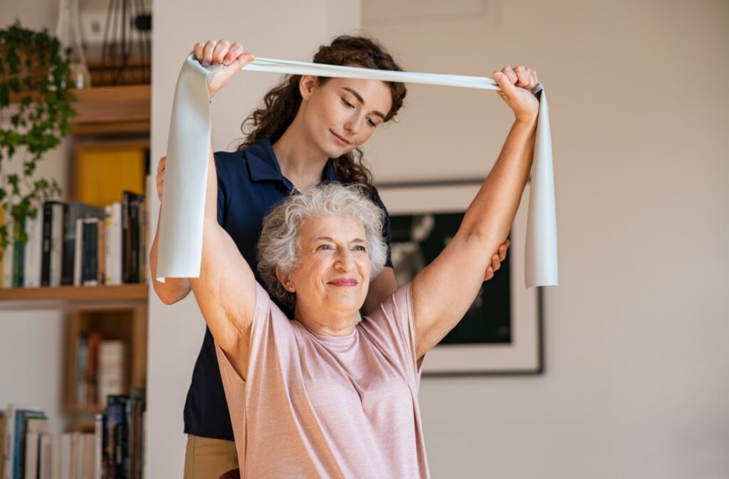 A nurse assists a senior living resident with some upper body stretches