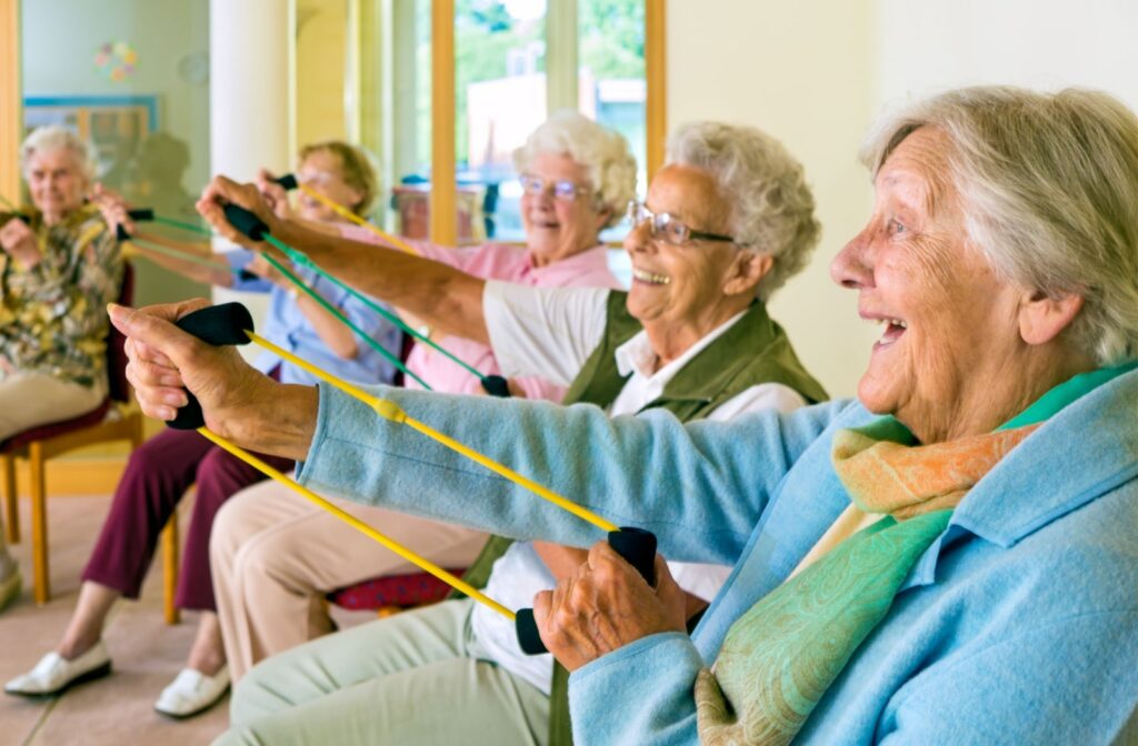 A group of senior living residents  practice muscle strengthening exercises together