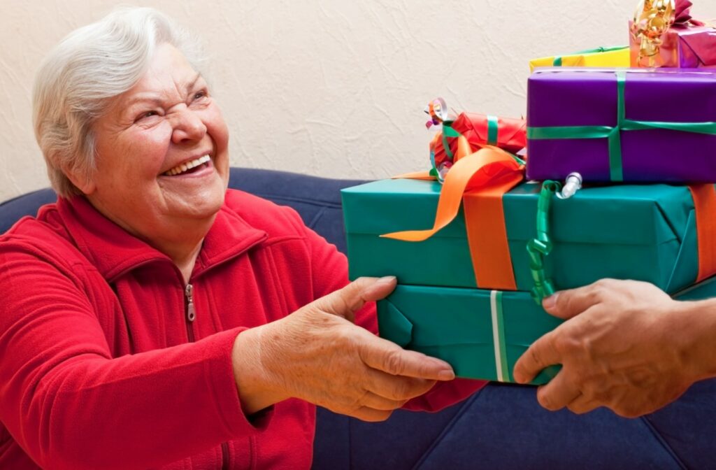 A senior woman receiving a few gifts from her loved ones for the holidays.