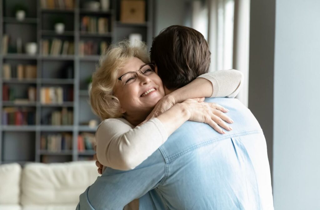 a senior woman hugs her adult son