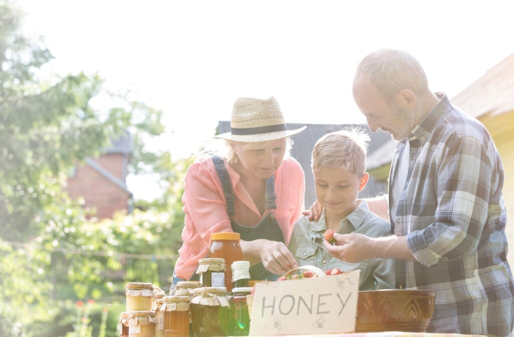 Grandparents pick out honey at a local market with their grandchild.