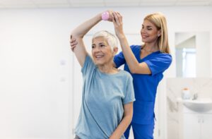 Physical therapist helping an older adult with their physical ailments as they age.