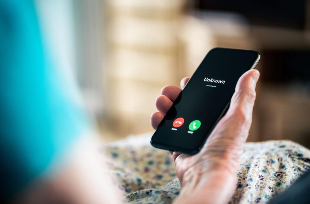 An unknown caller rings a senior as they look at their phone.